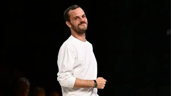 Matthieu Blazy, klädd i en vit långärmad tröja, ler mot kameran.